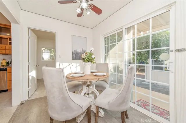 a dining room with furniture a floor to ceiling window and wooden floor