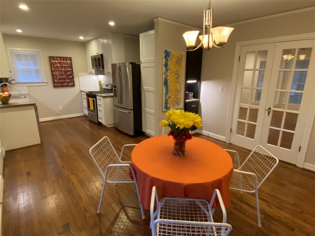 1531 Abrams Road Dallas, TX 75214 - Photo 1 of 1 a kitchen with stainless steel appliances kitchen island granite countertop a refrigerator a stove a microwave oven with a dining table and chairs