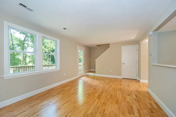 a view of a big room with wooden floor and a kitchen