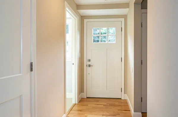 a view of an empty room with kitchen and a window