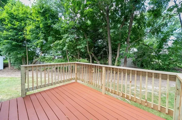 a balcony with wooden floor and outdoor seating