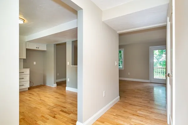 a bathroom with a toilet a sink a mirror and a window