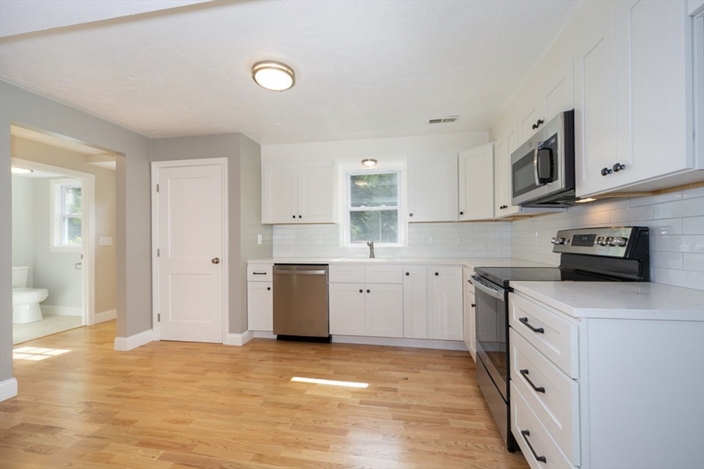 7 - Sherman Terrace, Unit 7 Natick, MA 01760 - Photo 5 of 26 a kitchen with stainless steel appliances granite countertop a stove a sink and a refrigerator