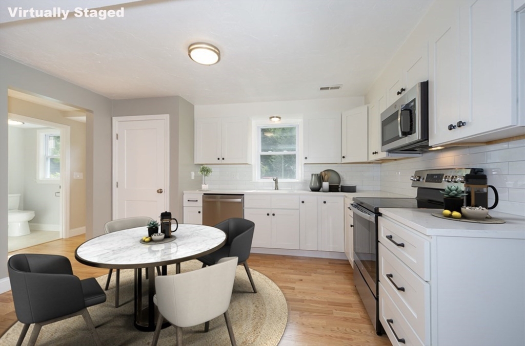 7 - Sherman Terrace, Unit 7 Natick, MA 01760 - Photo 6 of 26 a kitchen with stainless steel appliances a sink a stove a table and chairs