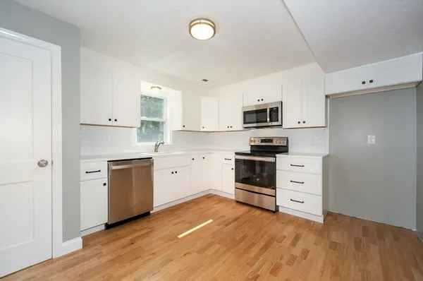 a kitchen with stainless steel appliances a stove top oven and cabinets