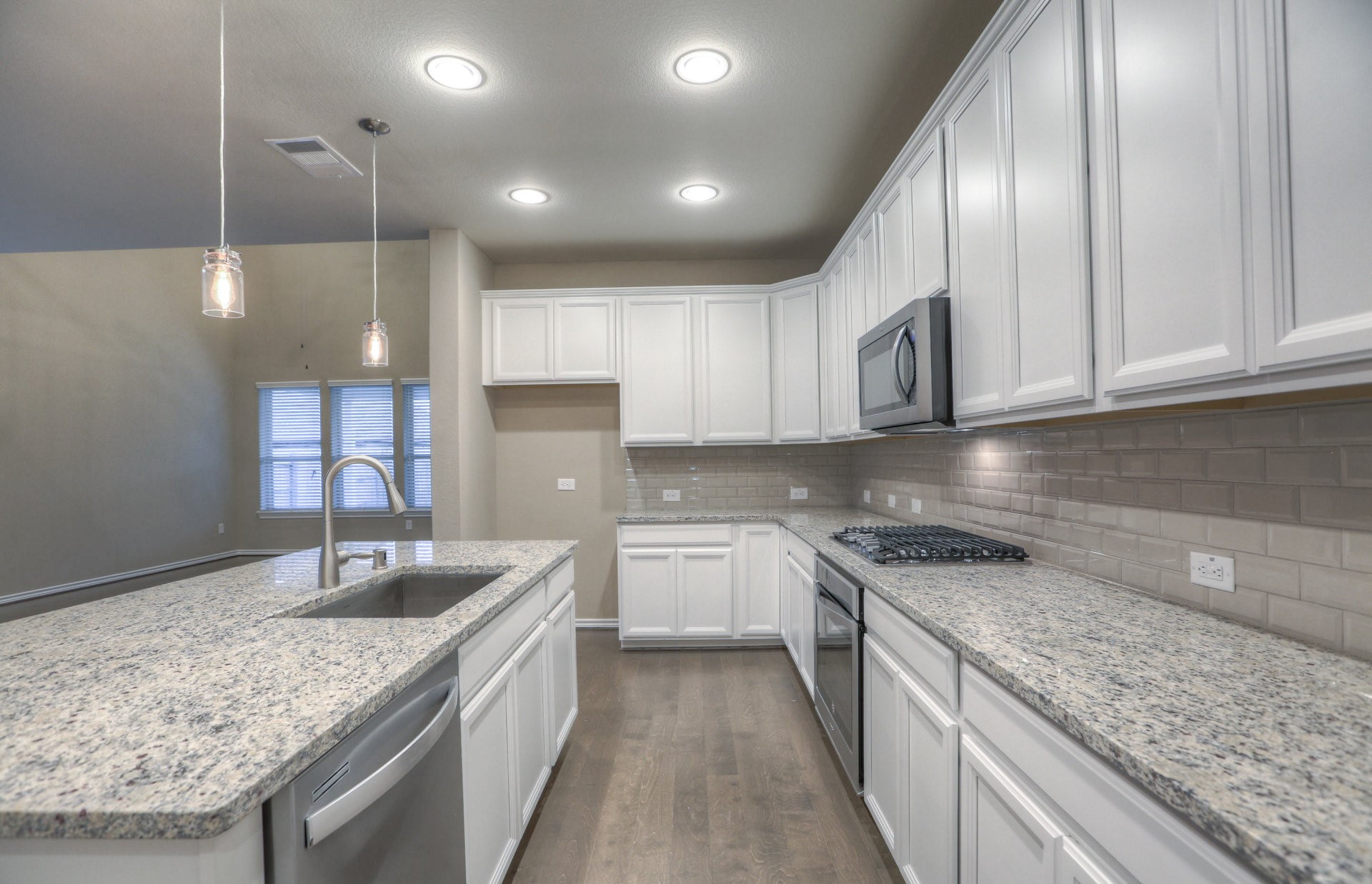 15166 Wild Gully Way Conroe, TX 77302 - Photo 9 of 21 a kitchen with kitchen island granite countertop a sink stainless steel appliances and cabinets