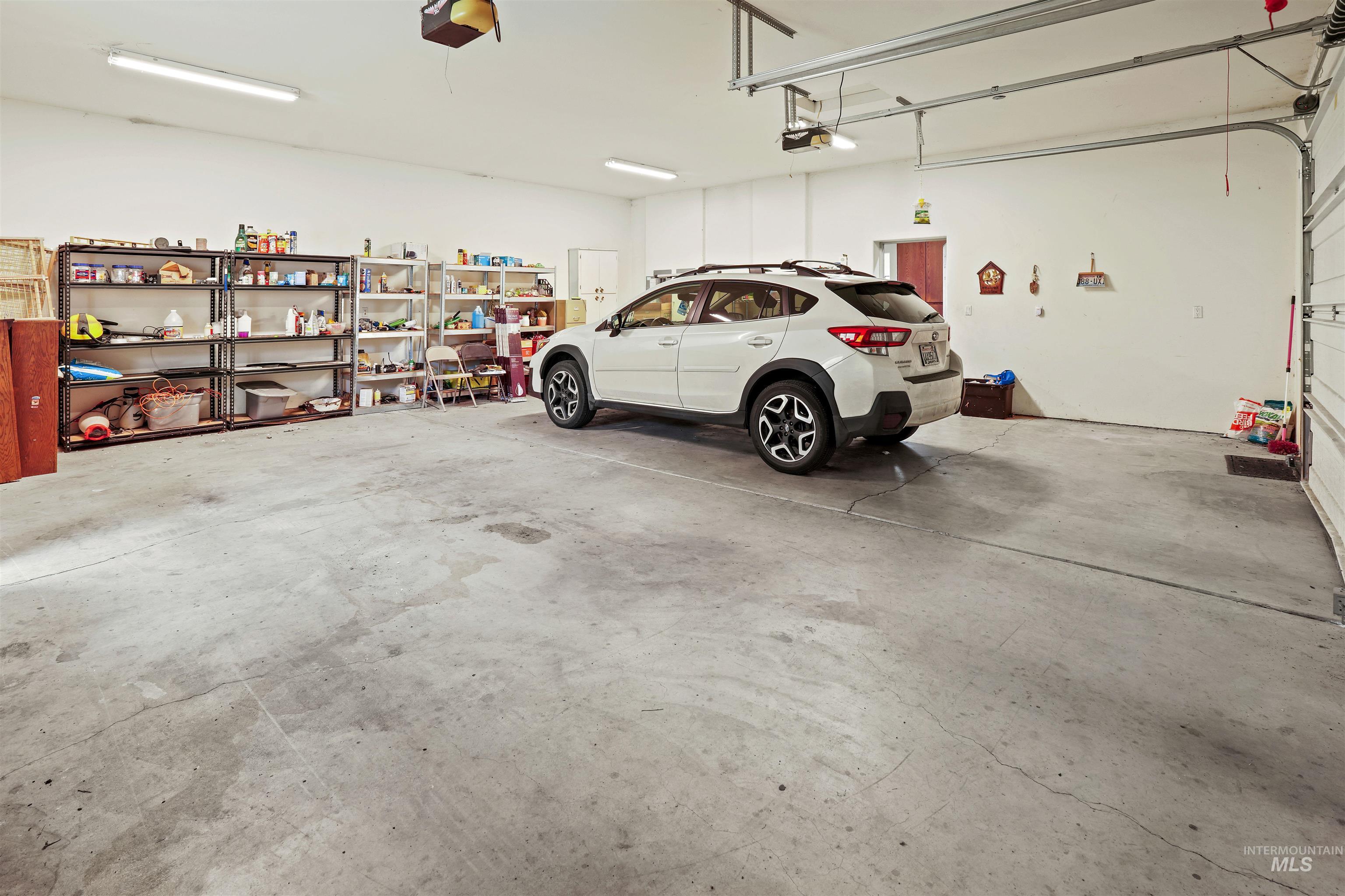 2750 South Perry Lane Clarkston, WA 99403 - Photo 22 of 47 Spacious garage featuring a concrete floor, bright overhead fluorescent lighting, and white painted walls