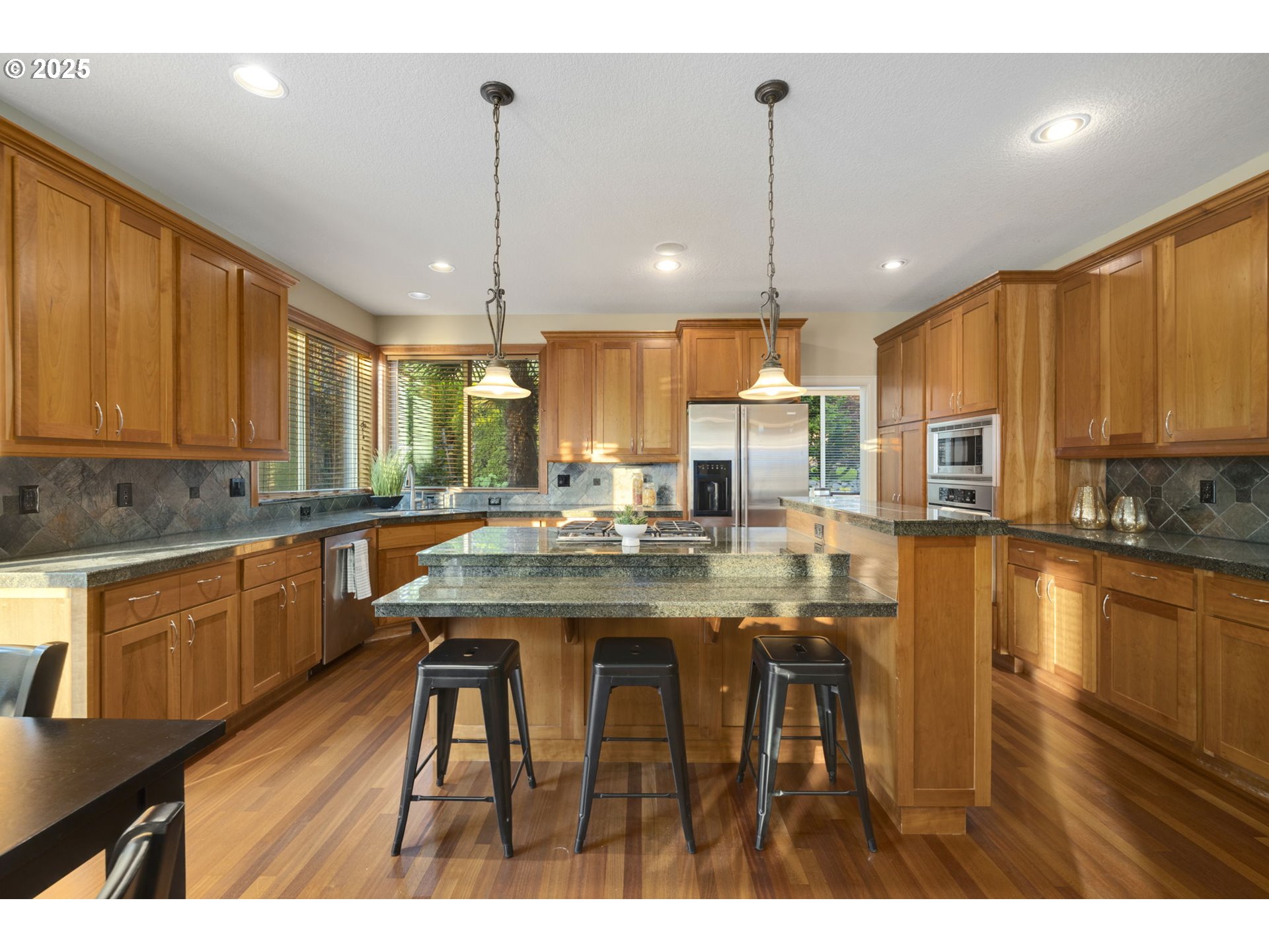 5219 Northwest Fernridge Drive Camas, WA 98607 - Photo 14 of 48 a kitchen with stainless steel appliances granite countertop wooden cabinets a sink a stove a dining table and chairs