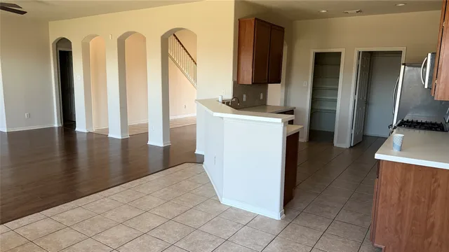 a view of a kitchen with fridge and wooden floor
