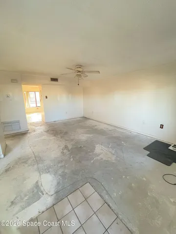 en empty room with windows and fan