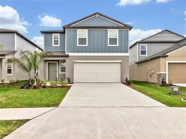 a front view of a house with a yard and garage