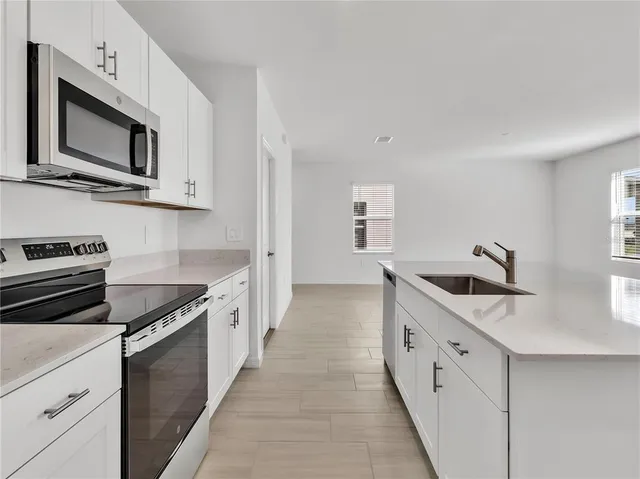 a kitchen with cabinets stainless steel appliances and sink