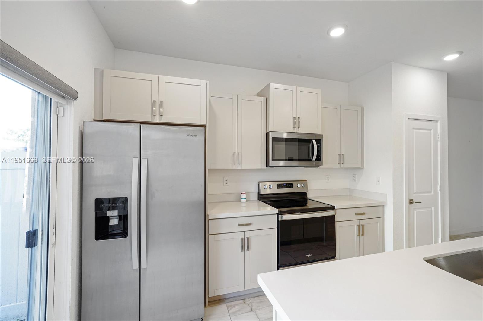 767 Southeast 18th Street Homestead, FL 33034 - Photo 5 of 29 a kitchen with stainless steel appliances a refrigerator stove and microwave