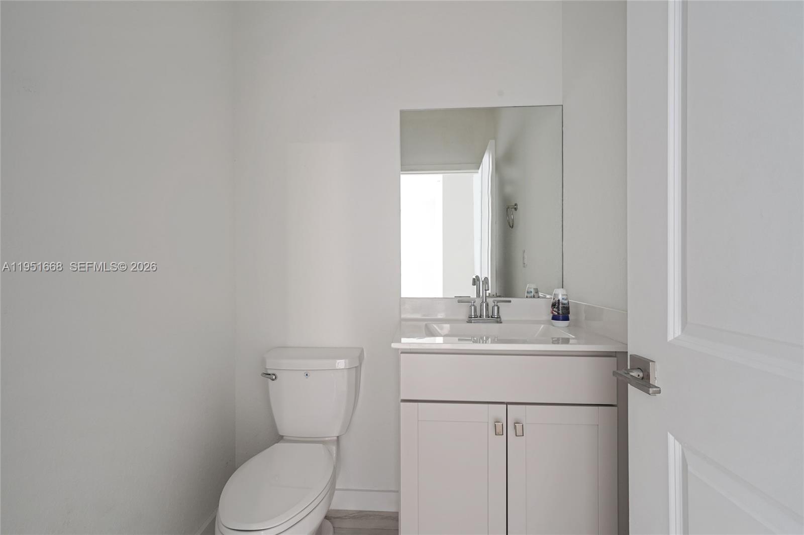 767 Southeast 18th Street Homestead, FL 33034 - Photo 10 of 29 a bathroom with a toilet sink vanity and mirror