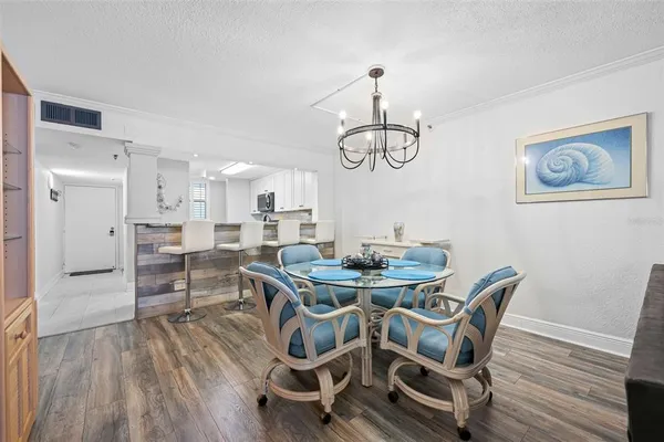 a dining room with furniture a chandelier and wooden floor