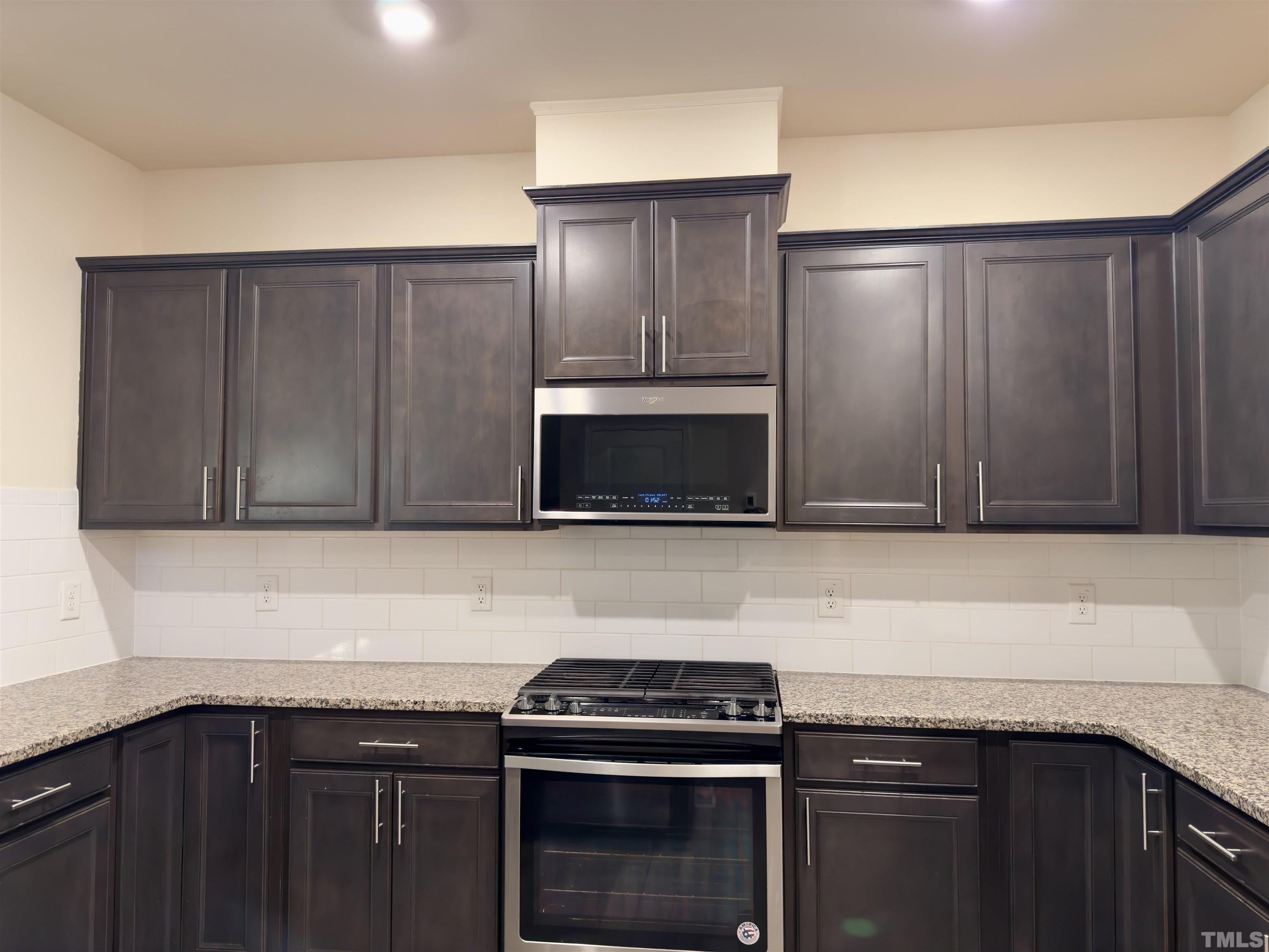 33 Rambler Lane Durham, NC 27703 - Photo 12 of 36 a kitchen with granite countertop wooden cabinets and stainless steel appliances