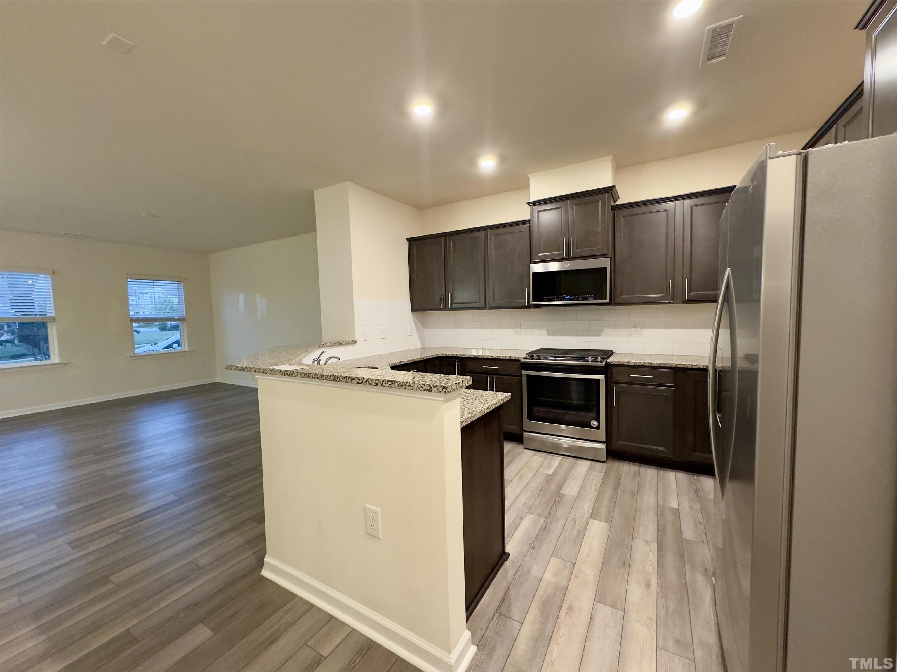 33 Rambler Lane Durham, NC 27703 - Photo 13 of 36 a kitchen with stainless steel appliances a stove top oven a sink and a refrigerator