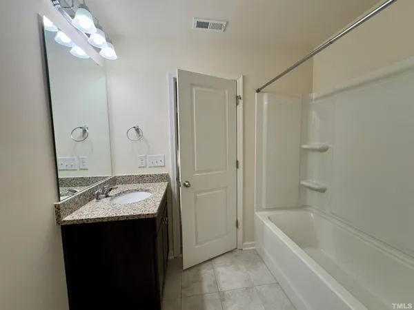 a bathroom with a tub sink and mirror