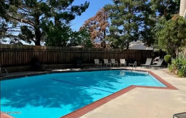 a view of backyard with swimming pool and furniture