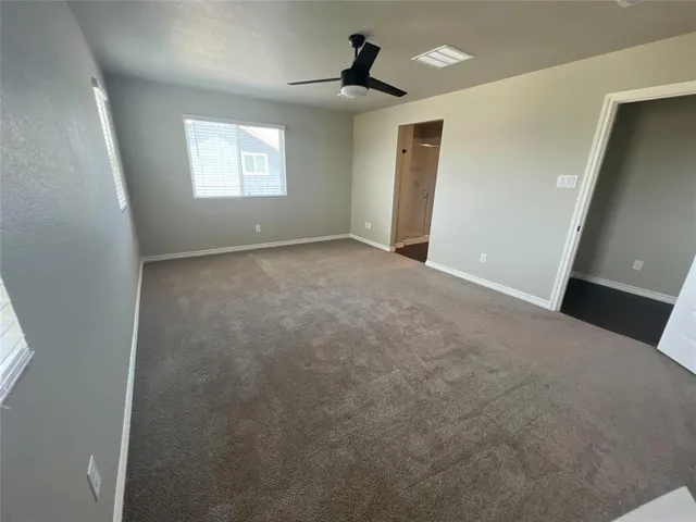 a view of an empty room with windows and cabinet