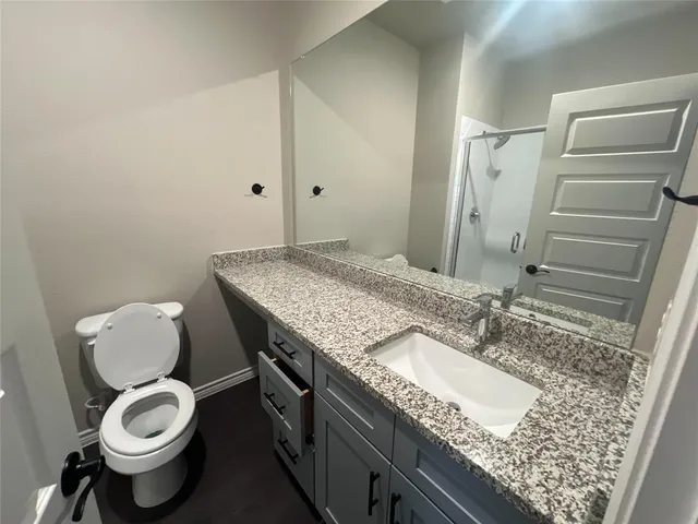 a bathroom with a granite countertop sink toilet and shower