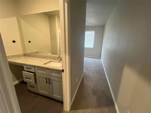 a bathroom with a granite countertop sink and a mirror