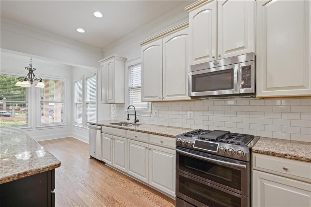 232 Hunt Street Northeast Marietta, GA 30060 - Photo 11 of 29 a kitchen with stainless steel appliances granite countertop a stove a sink and a microwave