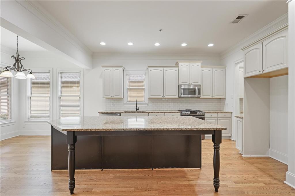232 Hunt Street Northeast Marietta, GA 30060 - Photo 9 of 29 a kitchen with stainless steel appliances granite countertop a sink a stove a refrigerator and island with wooden floor