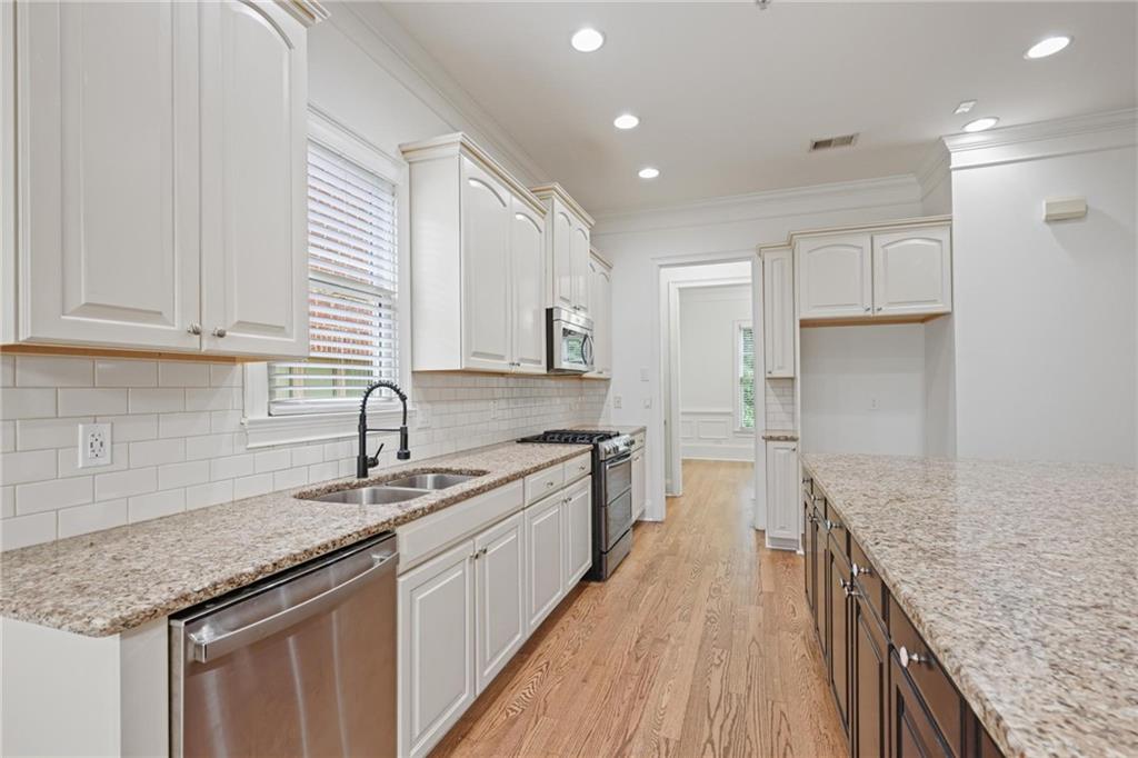 232 Hunt Street Northeast Marietta, GA 30060 - Photo 10 of 29 a kitchen with stainless steel appliances granite countertop a sink stove and cabinets