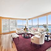 a living room with fireplace furniture and floor to ceiling window