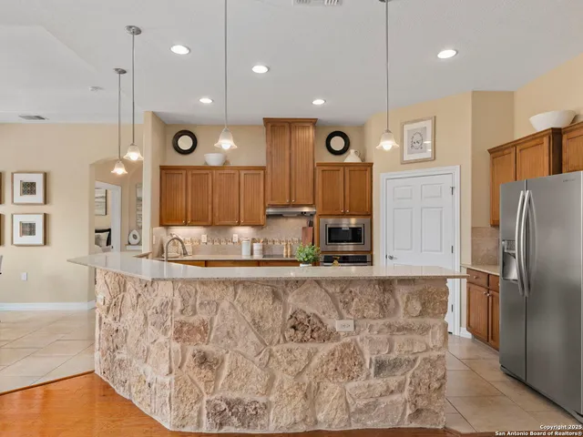 a living room with furniture kitchen area and a chandelier