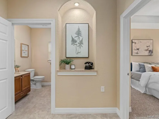 a bathroom with a granite countertop toilet a sink and a mirror