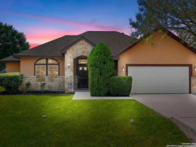 a front view of a house with a garden and yard