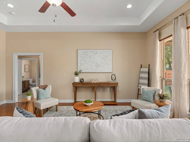 a living room with furniture kitchen view and a large window