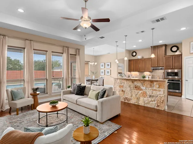 a living room with furniture kitchen view and a chandelier