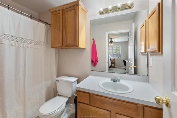 a bathroom with a sink toilet and mirror