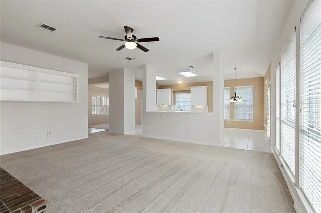 an empty room with fireplace and windows