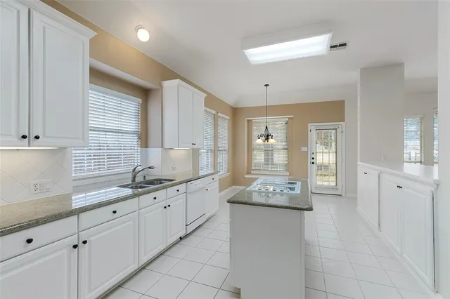 a kitchen with granite countertop white cabinets and white appliances