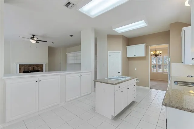 a view of a kitchen with kitchen island a sink a counter space and a window