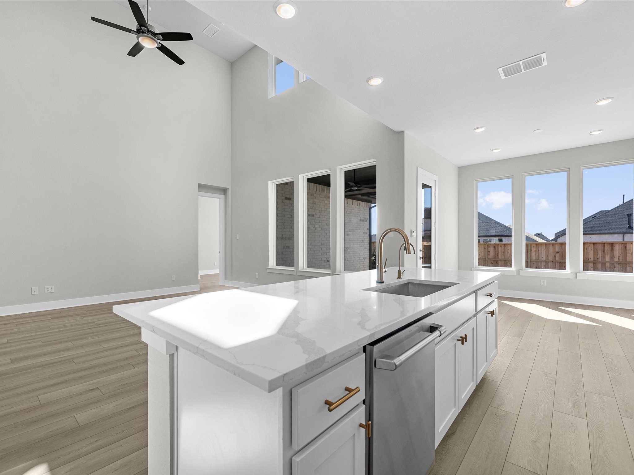 7922 Antler Rdg Drive Fulshear, TX 77441 - Photo 4 of 31 a large white kitchen with a sink and dishwasher with wooden floor