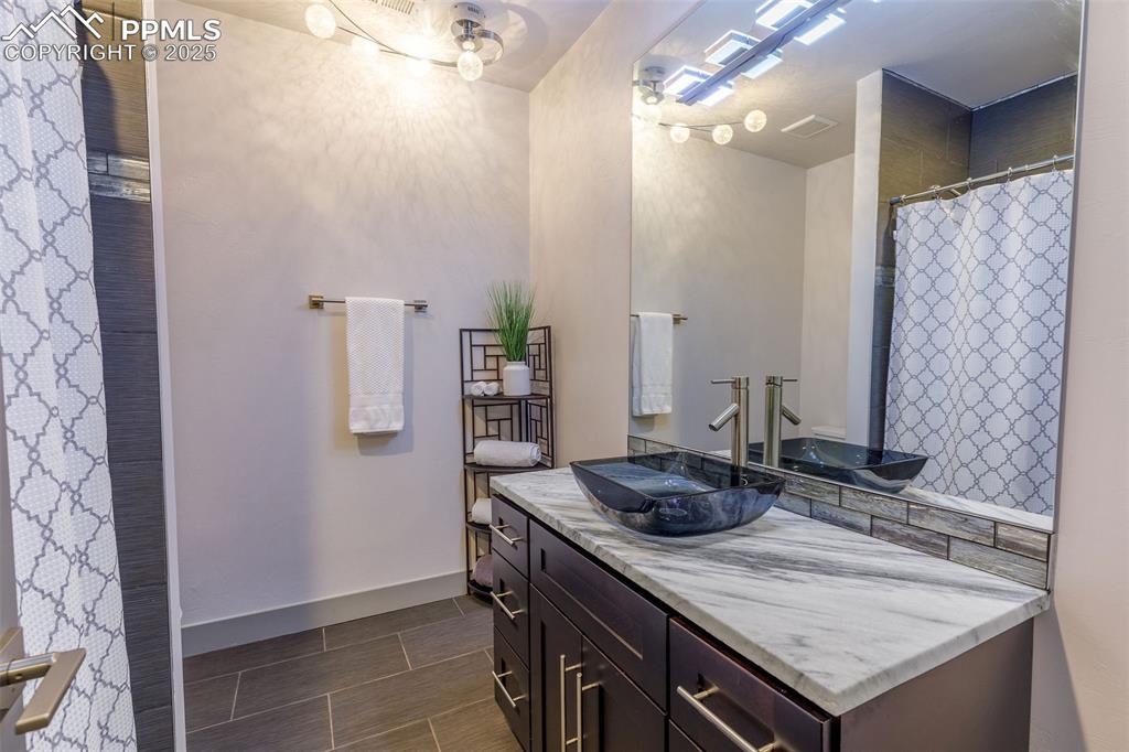 162 Crystal Valley Road Manitou Springs, CO 80829 - Photo 24 of 48 a bathroom with a granite countertop sink a toilet and shower