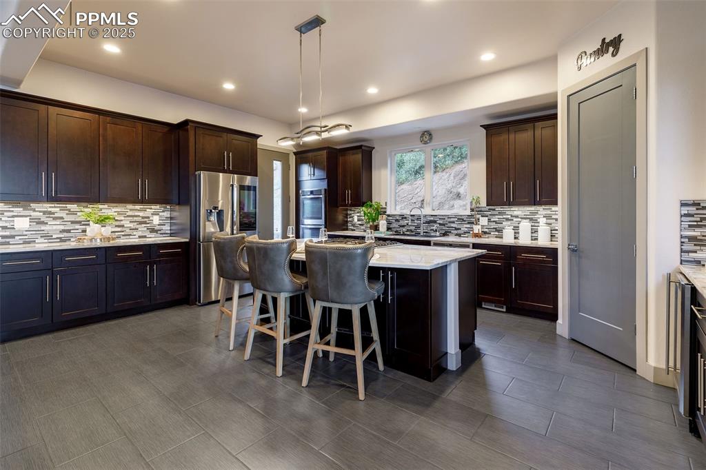 162 Crystal Valley Road Manitou Springs, CO 80829 - Photo 5 of 48 a kitchen with stainless steel appliances granite countertop table chairs sink and stove