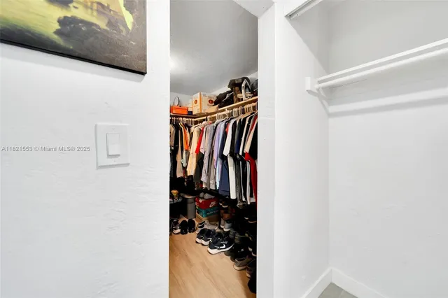 a view of walk in closet with clothes