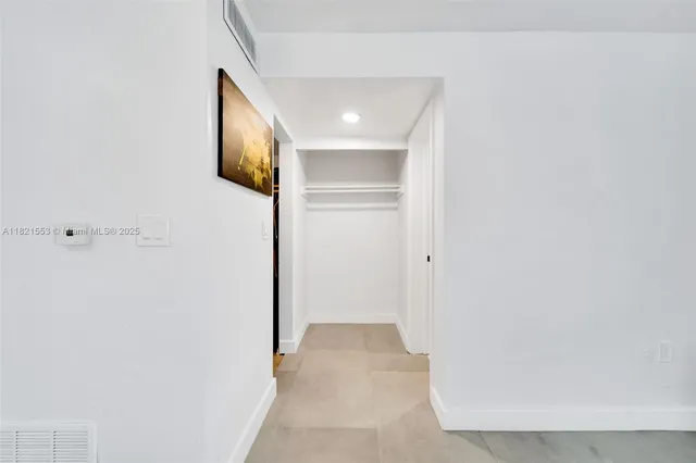 a view of a hallway with wooden floor and closet