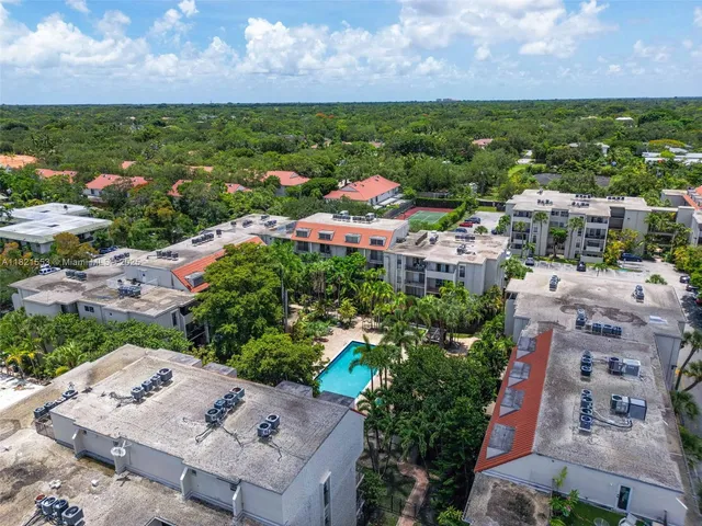 an aerial view of residential houses with outdoor space and trees