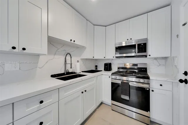 a kitchen with white cabinets and stainless steel appliances