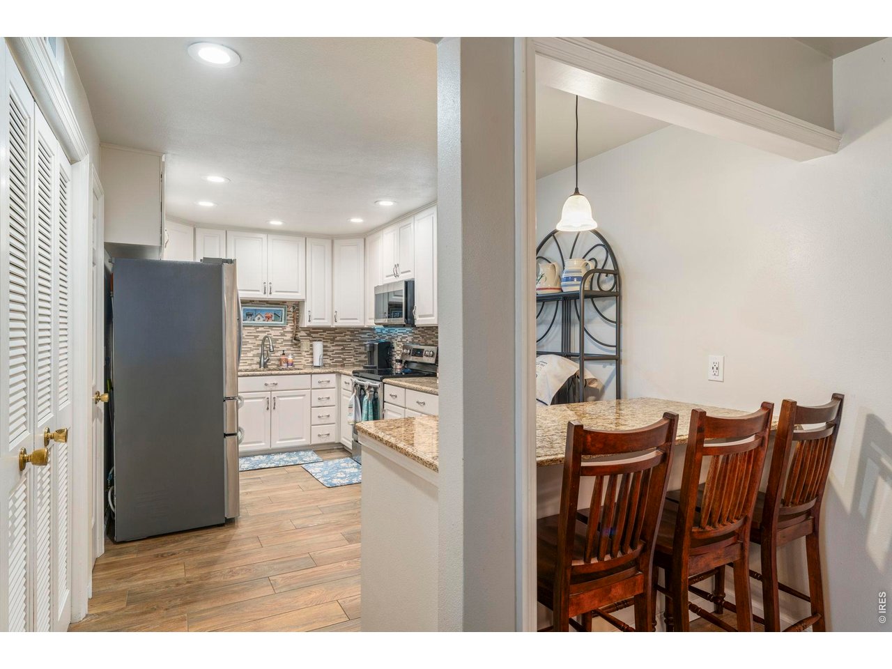39 Ward Drive, Unit 104 Greeley, CO 80634 - Photo 13 of 31 a kitchen with stainless steel appliances wooden cabinets and dining table