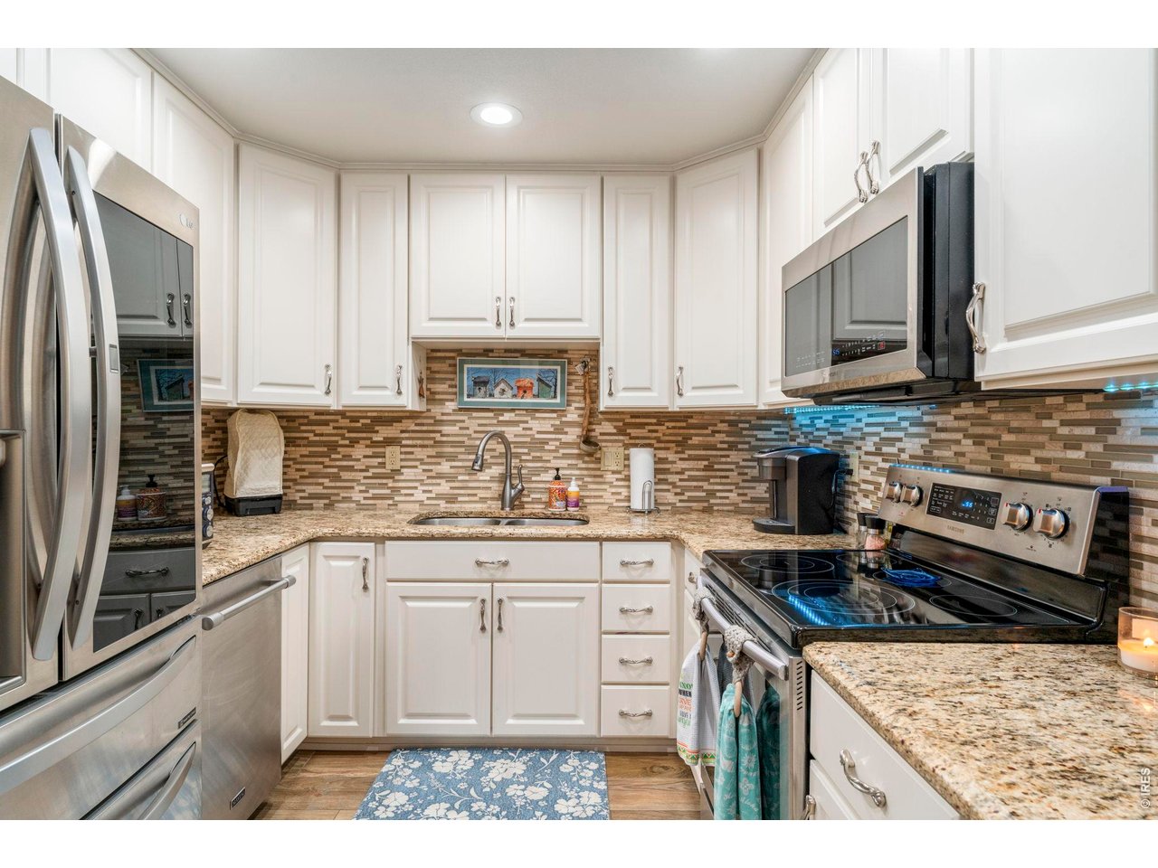 39 Ward Drive, Unit 104 Greeley, CO 80634 - Photo 15 of 31 a kitchen with stainless steel appliances granite countertop a stove a sink dishwasher and a refrigerator
