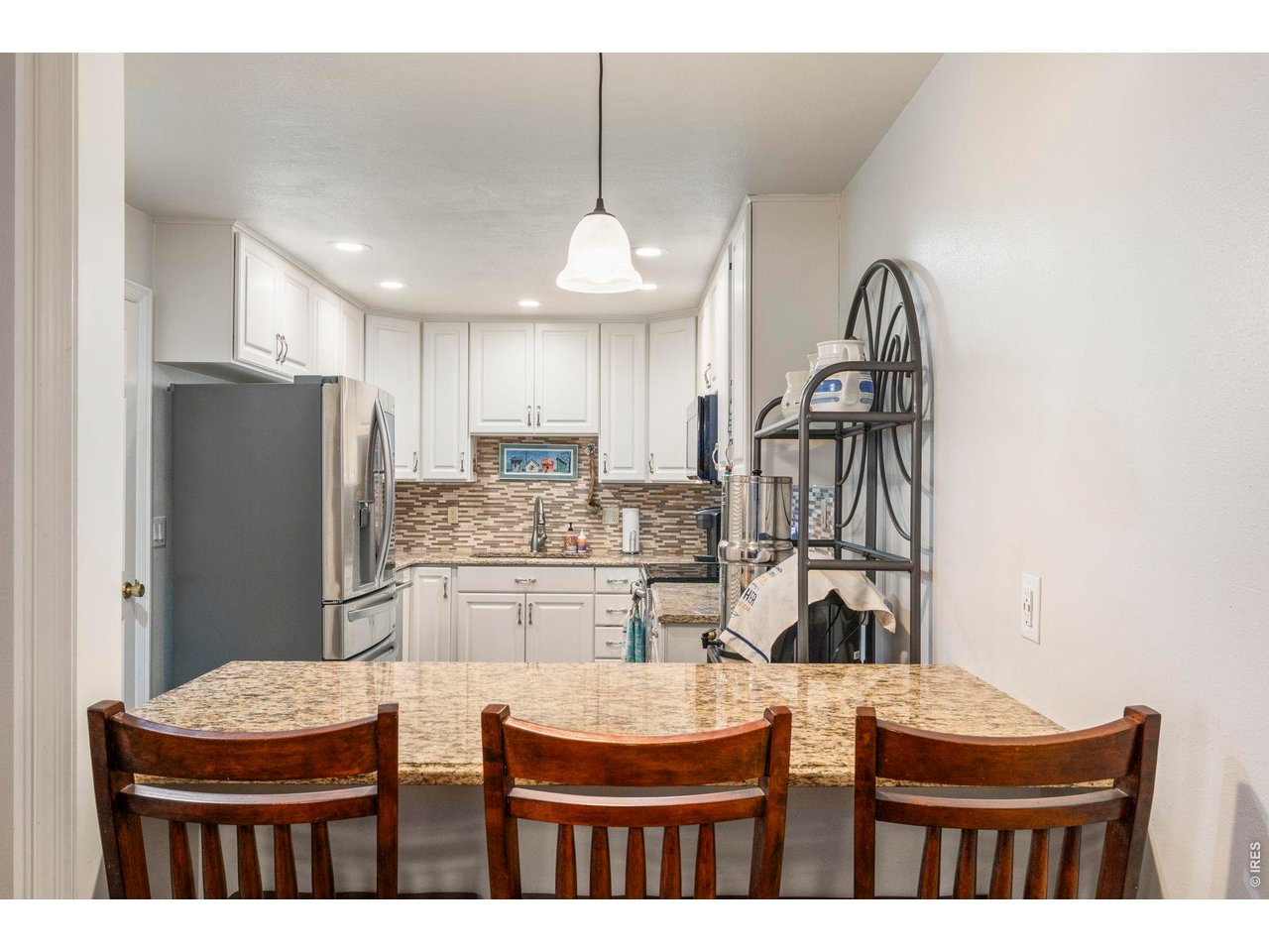 39 Ward Drive, Unit 104 Greeley, CO 80634 - Photo 16 of 31 a kitchen with stainless steel appliances kitchen island granite countertop a refrigerator and microwave