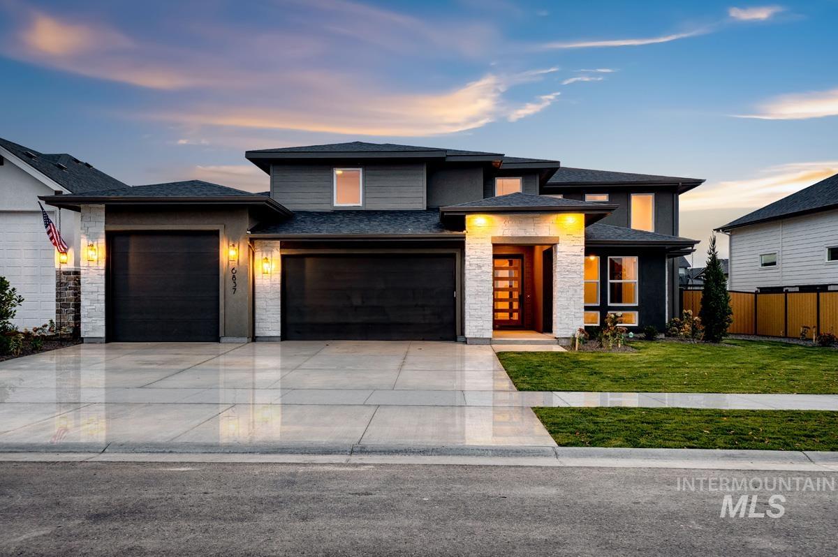 Prairie-style home featuring stone siding, concrete driveway, a garage, and roof with shingles
